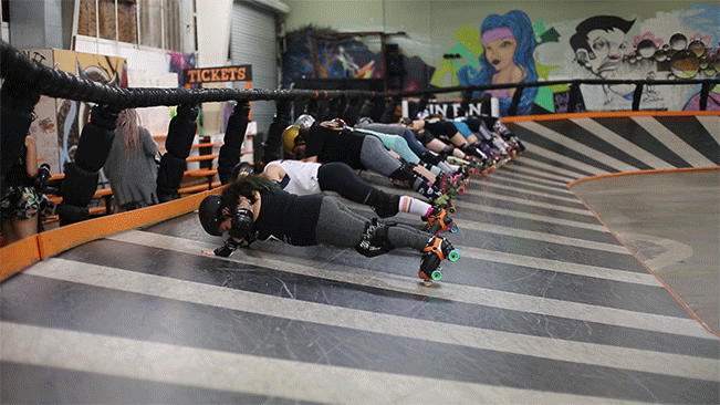 Roller Derby Team doing push ups on a banked track