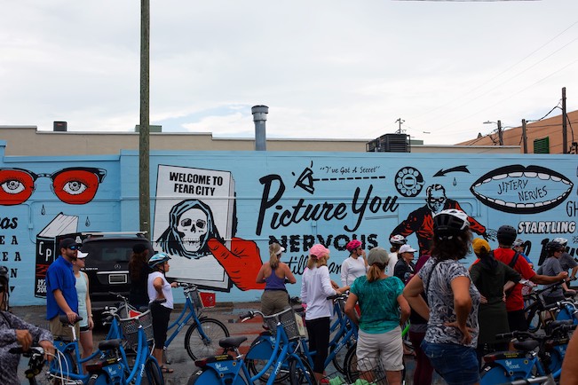 Cyclists observe a mural in St. Petersburg 