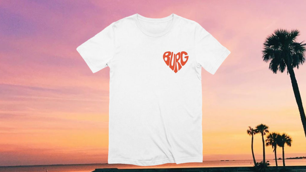 white shirt with red "burg" text in shape of heart on a photo of a sunset in the background