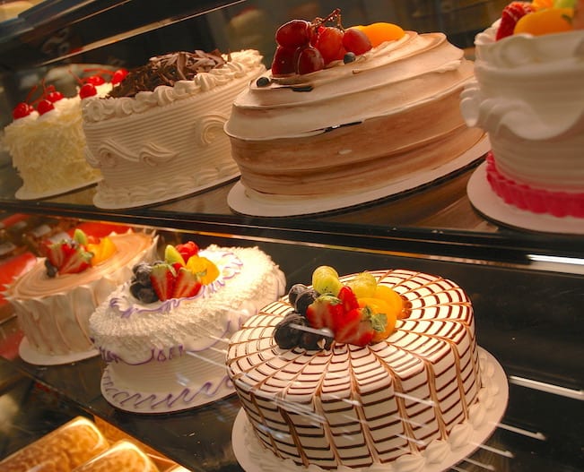 Assortment of cakes behind glass in a grocery store