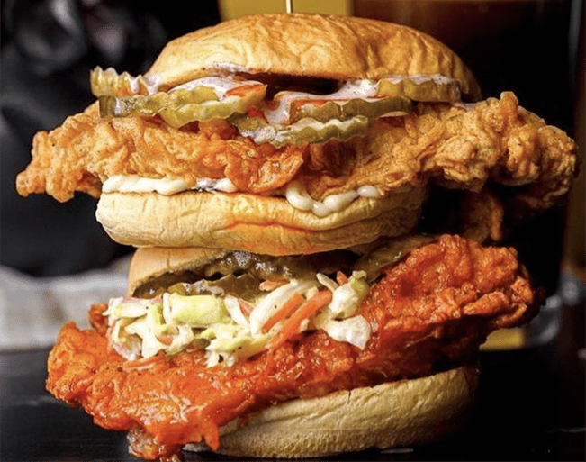 two spicy chicken sandwiches with pickles, and colslaw