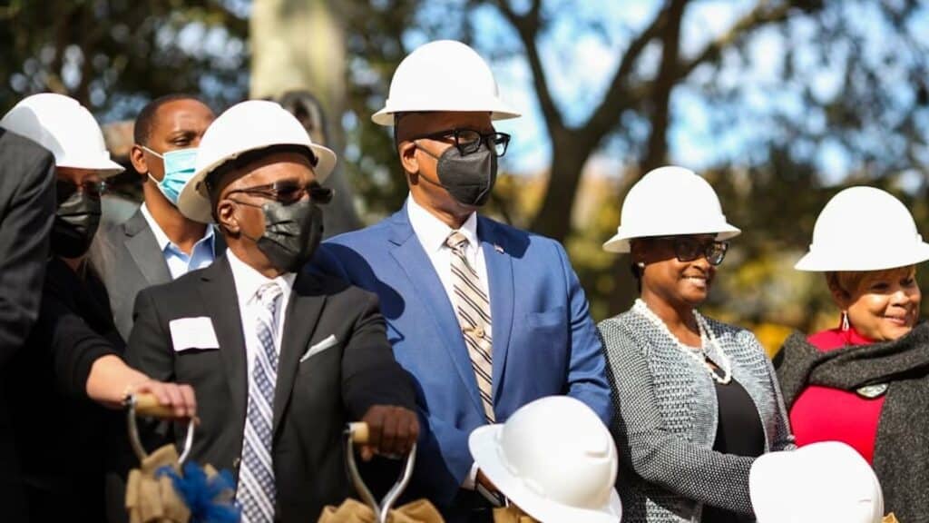 a group of people in hard hats participating in a groundbreaking ceremony